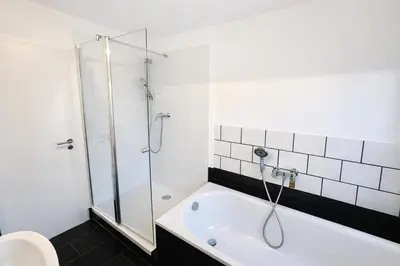 Ein Badezimmer in der Unterkunft Moderne 3-Zi, King-Size Betten, Küche, Badewanne
