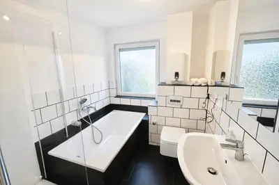 Ein Badezimmer in der Unterkunft Moderne 3-Zi, King-Size Betten, Küche, Badewanne