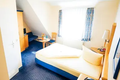 Ein Bett oder Betten in einem Zimmer der Unterkunft Hotel Sauer Garni