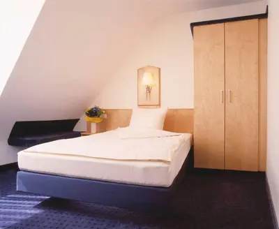 Ein Bett oder Betten in einem Zimmer der Unterkunft Hotel Sauer Garni